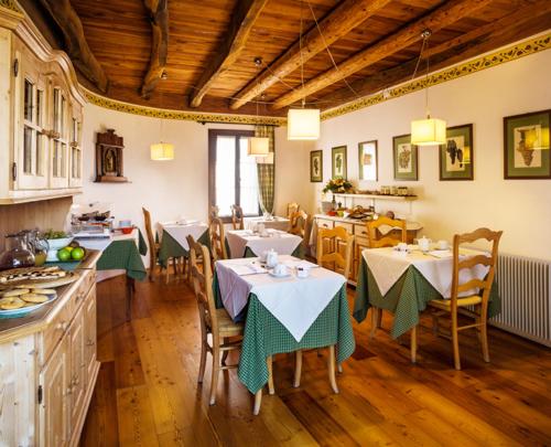 cocina y comedor con mesas y sillas en B&B Gastaldo di Rolle, en Cison di Valmarino