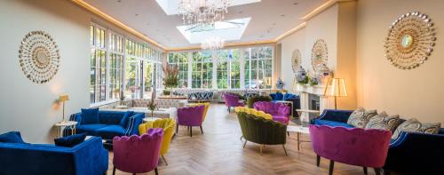 a room with chairs and tables and a chandelier at Cork's Vienna Woods Hotel & Villas in Cork