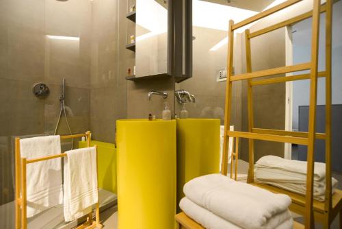 W łazience znajduje się żółta umywalka i lustro. w obiekcie Exclusive Loft Salerno Centro w mieście Salerno