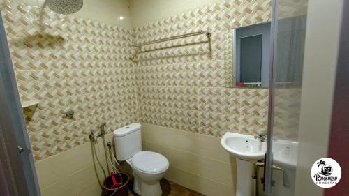 a bathroom with a toilet and a sink at RIVERVIEW HOMESTAY PERLIS in Kangar