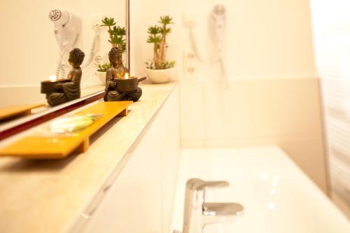 a bathroom with a sink and a mirror and a tub at Hotel Römerstadt in Gersthofen