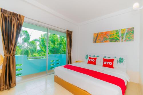 a bedroom with a bed and a large window at OYO 614 Koh Lak Resort in Prachuap Khiri Khan