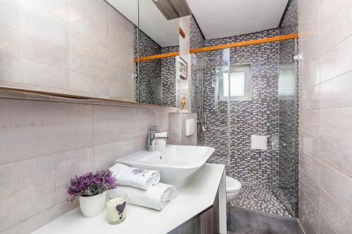 a white bathroom with a sink and a shower at Apartment Presker in Šilo