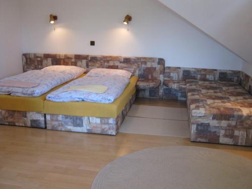 two twin beds in a room with a couch at Privat Apartma Ulrych in Liberec