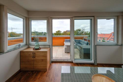 a living room with windows and a view of a balcony at Heidequartier Harz in Wernigerode