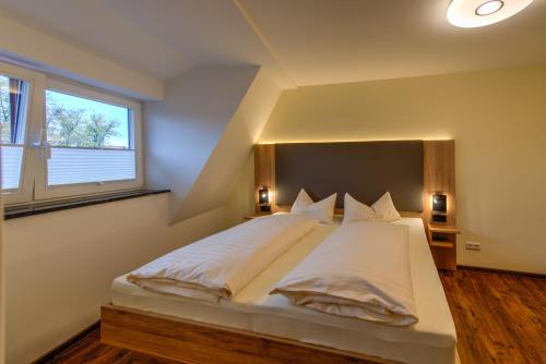 a bedroom with a large white bed with a large window at Heidequartier Harz in Wernigerode