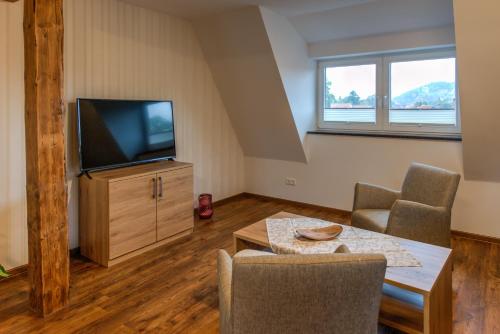 a living room with a tv and a table and chairs at Heidequartier Harz in Wernigerode