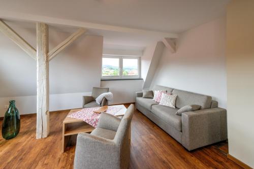 a living room with a couch and two chairs at Heidequartier Harz in Wernigerode