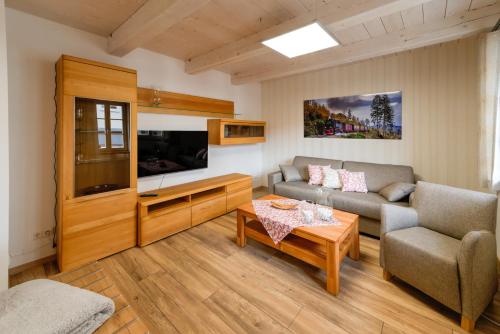 a living room with a couch and a tv at Heidequartier Harz in Wernigerode