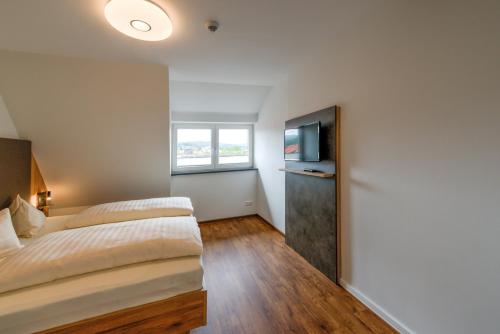 a bedroom with a bed and a television at Heidequartier Harz in Wernigerode