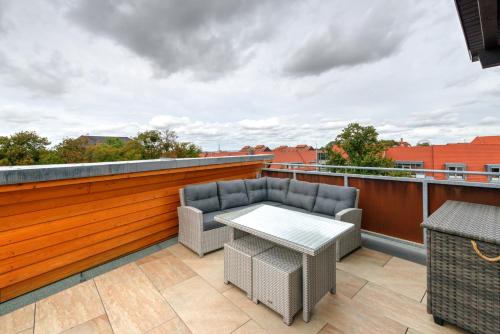 a patio with a table and chairs on a roof at Heidequartier Harz in Wernigerode