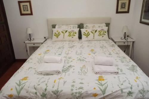 a bedroom with a large bed with a floral bedspread at Casa rural Mertxenea Landetxea in Elcano