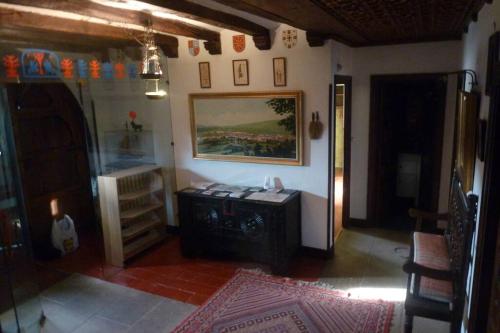a living room with a table and a painting on the wall at Casa rural Mertxenea Landetxea in Elcano