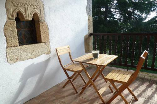 a wooden table and two chairs on a patio at Casa rural Mertxenea Landetxea in Elcano