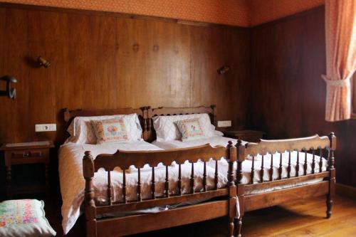 a wooden bed in a bedroom with wooden walls at Casa rural Mertxenea Landetxea in Elcano