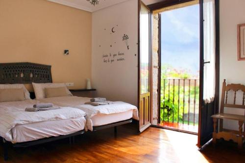 a bedroom with a bed and a sliding glass door at Casa rural Mertxenea Landetxea in Elcano