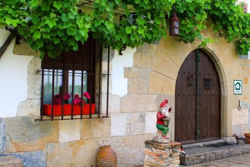 a building with a door and a statue in front of a window at Casa rural Mertxenea Landetxea in Elcano