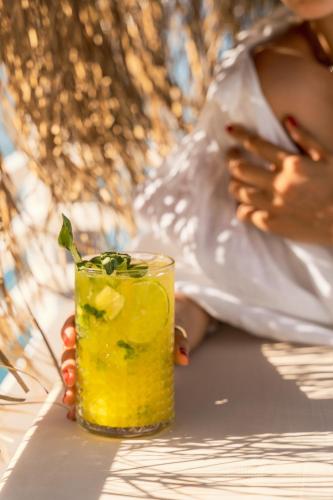 a woman is holding a glass with a drink at Torbahan Hotel in Torba