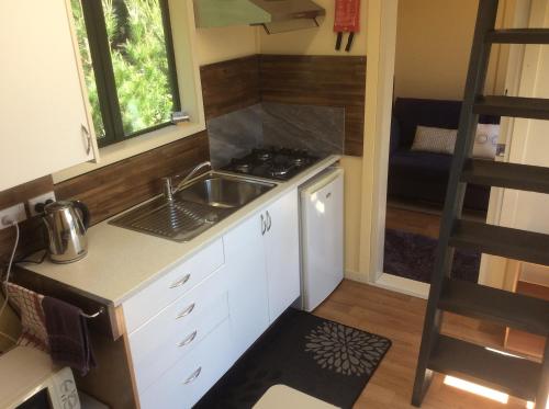 a tiny kitchen with a sink and a stove at Oxford Tiny House in Oxford