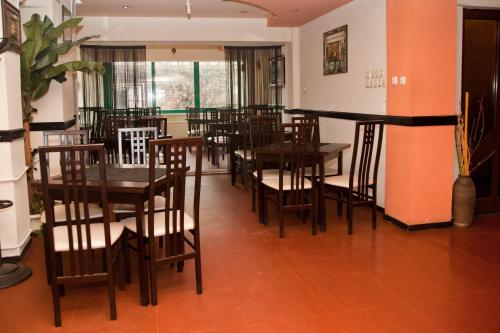 a dining room with wooden tables and chairs at Hotel Metropol in Piteşti