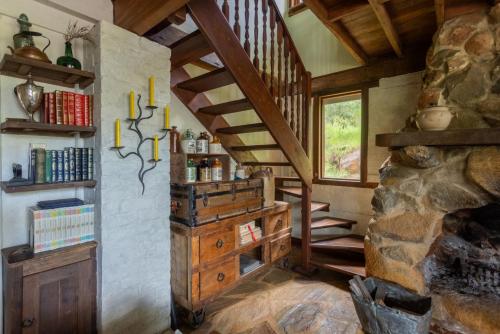 a room with a staircase and a stone fireplace at The Getaway Roleystone in Roleystone