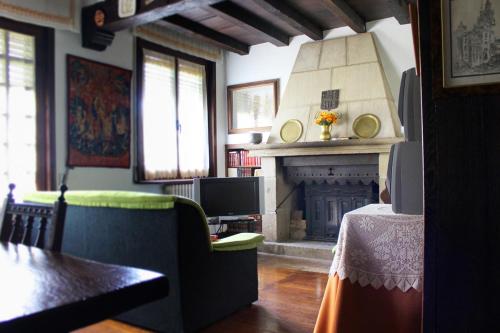 a living room with a fireplace and a green couch at Casa rural Mertxenea Landetxea in Elcano