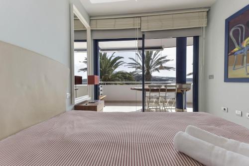 a bedroom with a bed and a view of the ocean at Merlín 1-1 in Playa de San Juan