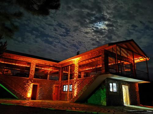 un edificio de ladrillo por la noche con la luna en el cielo en Fikri Atalay Konağı Bungalov Evleri, en Mengen