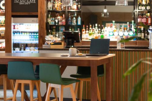 a bar with a table with a laptop on it at Holiday Inn Ashford - North A20 by IHG in Ashford
