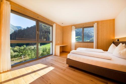 a bedroom with two beds and a large window at Camping Zögghof in San Leonardo in Passiria