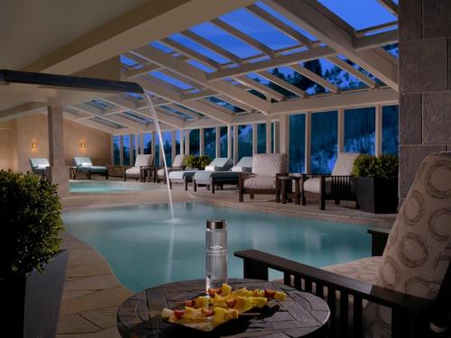 a pool in a hotel with a table with fruit on it at One Ski Hill Place, a RockResort, by Vail Resorts in Breckenridge