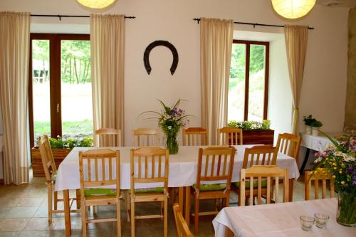 a dining room with a table and chairs and windows at Penzion Starý Pivovar in Křtiny