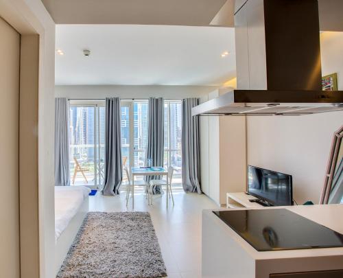 a room with a kitchen and a living room at Stylish Studio in West Avenue Dubai Marina in Dubai