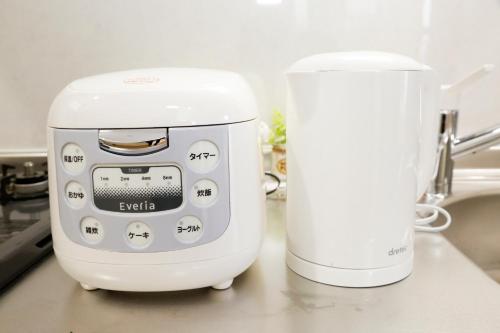 a white appliance sitting on a counter next to a mixer at Tokyo Enjoy Hotel in Tokyo