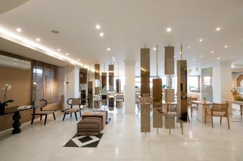 a lobby with chairs and tables in a building at Elounda Akti Olous (Adults Only) in Elounda