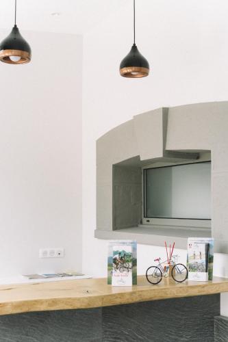a kitchen with three lights and a counter with books at L'Argalyde Esprit Pyrénées Wellness & Cycling in Ayzac-Ost