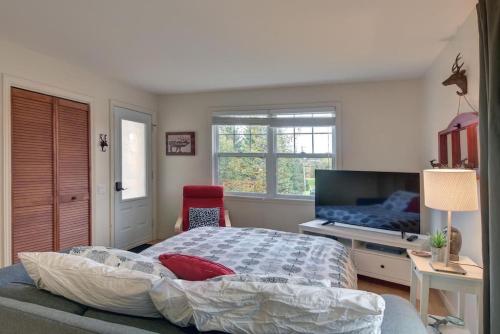 a bedroom with a bed and a flat screen tv at Tranquility Lodge by Instant Suites in Mont-Tremblant