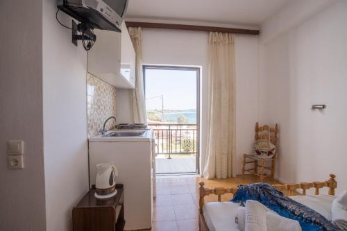 1 dormitorio con 1 cama y cocina con ventana en Ananias By Hotelius, en Agios Georgios