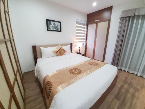 a bedroom with a large white bed in a room at REIWA INN APARTMENT in Hanoi