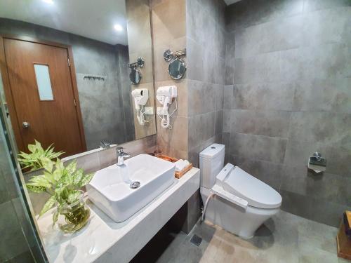 a bathroom with a white sink and a toilet at REIWA INN APARTMENT in Hanoi
