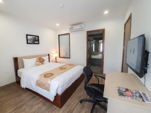 a bedroom with a bed and a desk and a television at REIWA INN APARTMENT in Hanoi