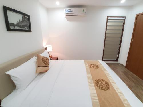 a bedroom with a large white bed in a room at REIWA INN APARTMENT in Hanoi