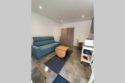 un salon avec un canapé bleu et une table dans l'établissement Studio idéalement situé au calme, à Lorient