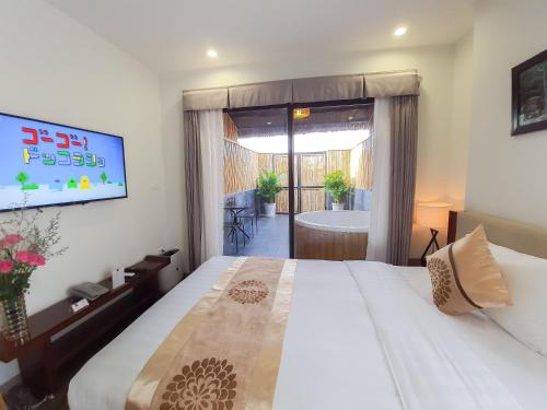 a bedroom with a bed and a tub and a television at REIWA INN APARTMENT in Hanoi