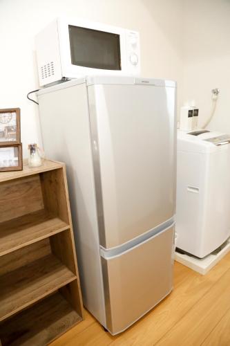 a white refrigerator with a microwave on top of it at Tokyo Enjoy Hotel in Tokyo