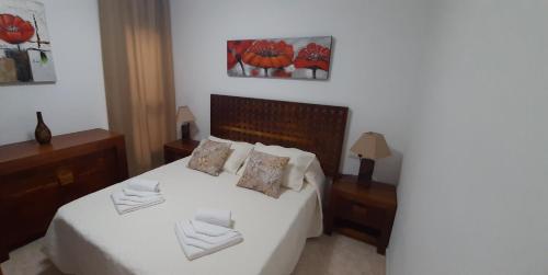 Schlafzimmer mit einem Bett mit weißer Bettwäsche und Kissen in der Unterkunft Casa Corvina in Playa Blanca