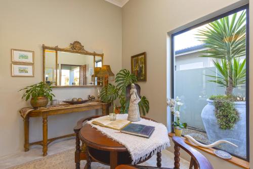 a room with a table with a mirror and plants at Le Mahi Guest House in Langebaan