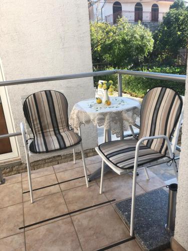 2 chaises et une table sur un balcon dans l'établissement Apartments Kraljev Stanko, à Biograd na Moru