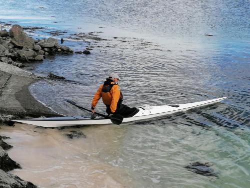 a man sitting on a kayak in the water at The Fisherman's Snug self catering North Uist in Paible