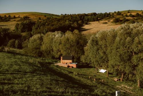 a barn in the middle of a field with trees at Sielska Chyża in Rzepedż